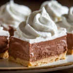 Close-up of French Silk Pie Bars with silky chocolate filling, buttery crust, and whipped cream topping.